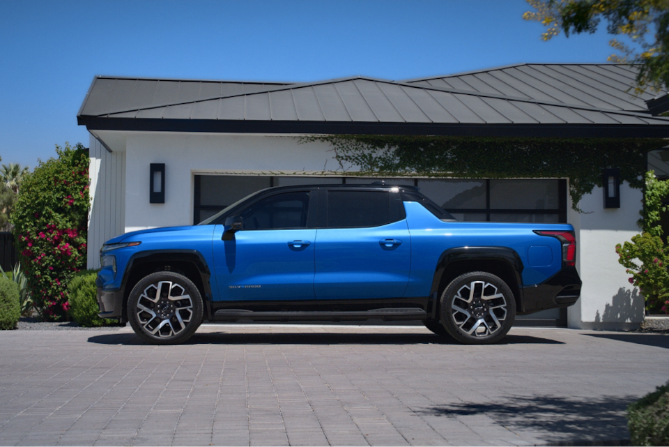 Side-profile view of the 2024 Chevrolet Silverado EV parked outside a house.