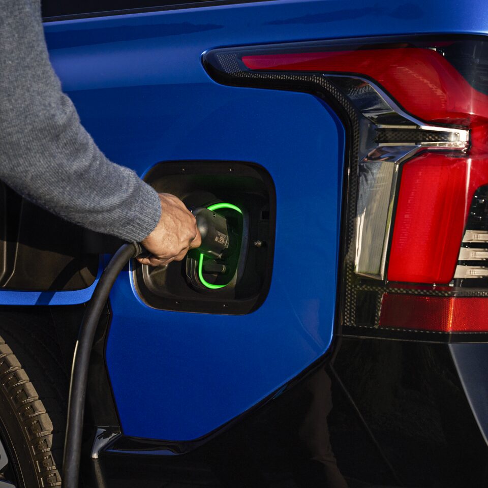 A person plugging in a 2024 Chevrolet Silverado EV into the charging station.