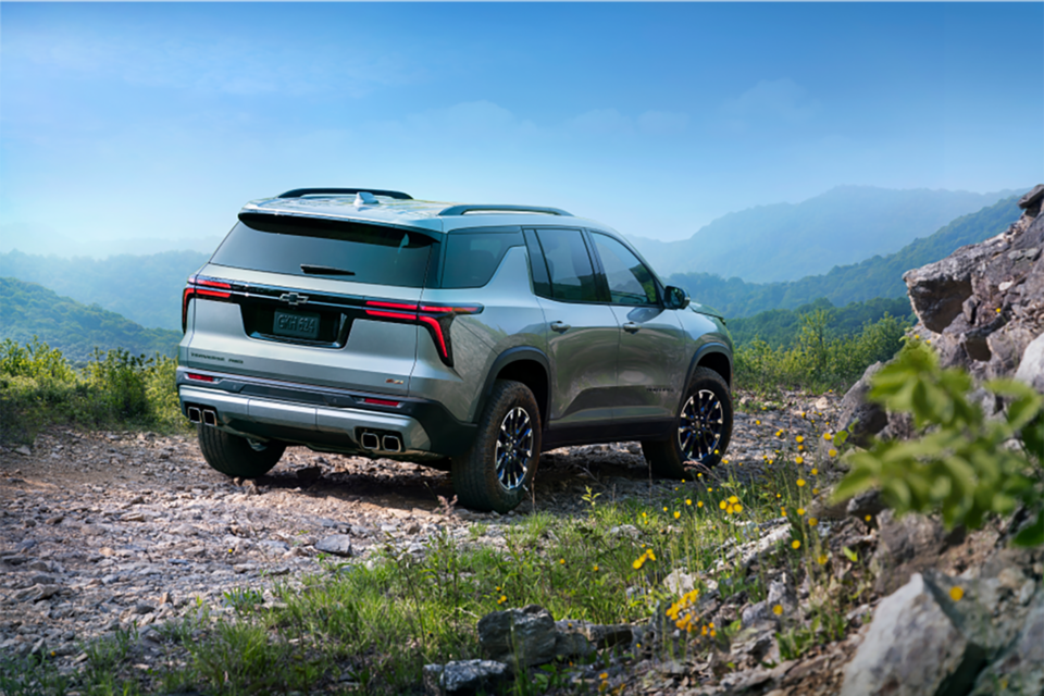 Rear view of the 2024 Traverse driving on rocky terrain.