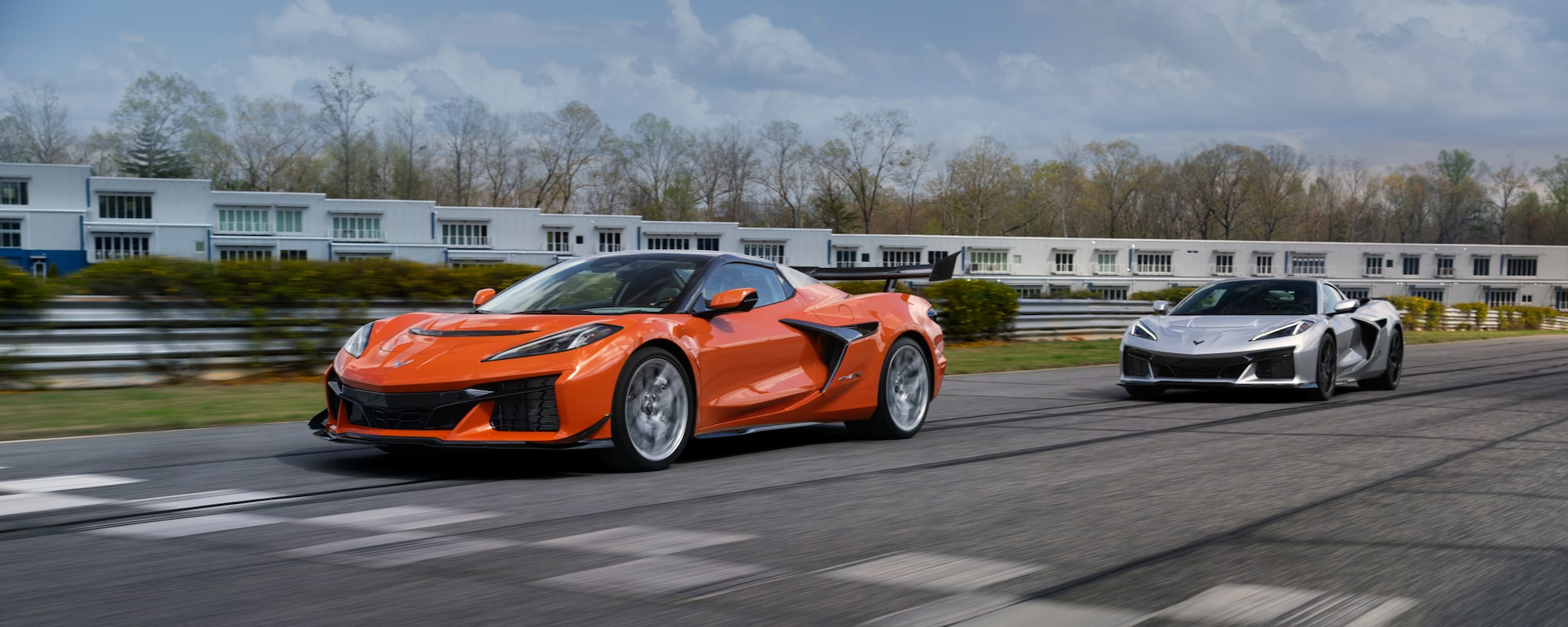 Two Chevrolet Corvette ZR1s driving on a racetrack on a sunny day.