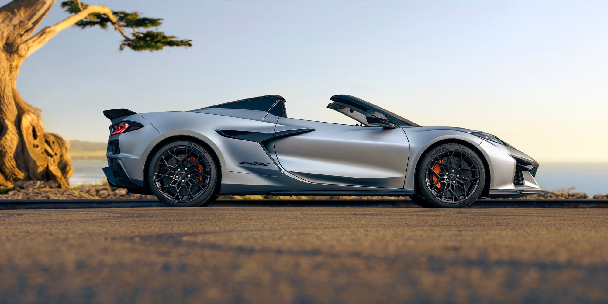 Vue latérale de la Chevrolet Corvette ZR1X 2026 garée près de l’océan.