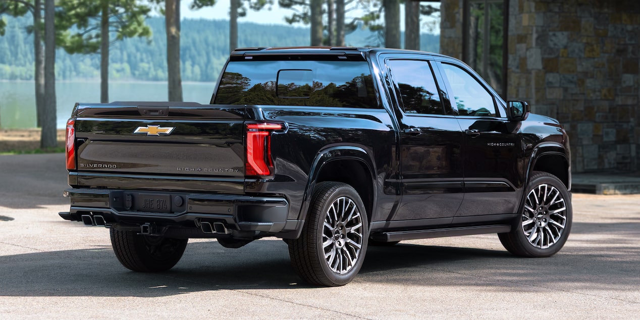 Rear-side view of the Next-Generation 2027 Silverado 1500 Truck parked outdoors on a sunny day.