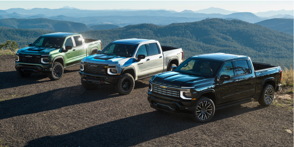 Three 2027 Chevrolet Silverado 1500 trucks lined up at a mountain overlook