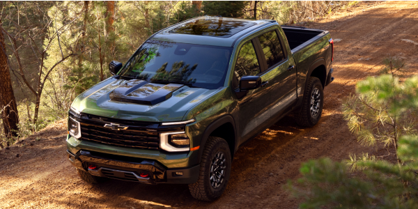 Green 2027 Chevrolet Silverado 1500 Trail Boss on a wooded off-road trail
