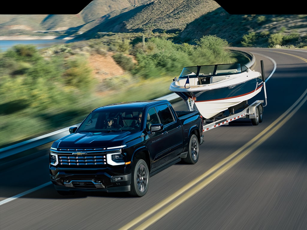 A Next-Generation 2027 Silverado 1500 Truck towing a boat on the road.