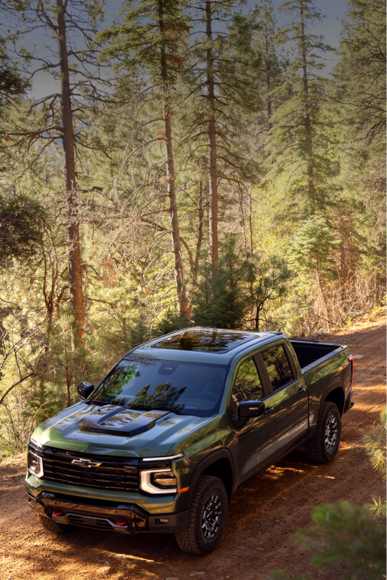 Green 2027 Chevrolet Silverado 1500 Trail Boss off-roading on a rocky hill