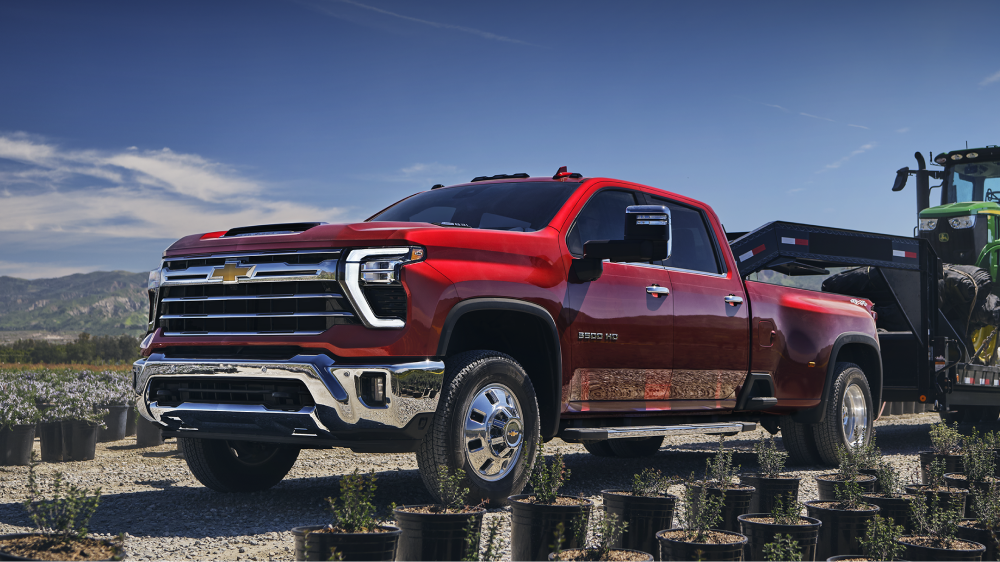 Le nouveau pick-up Chevrolet Silverado HD Custom 2027 stationné dans une pépinière agricole, montré d’un angle avant aux trois quarts.