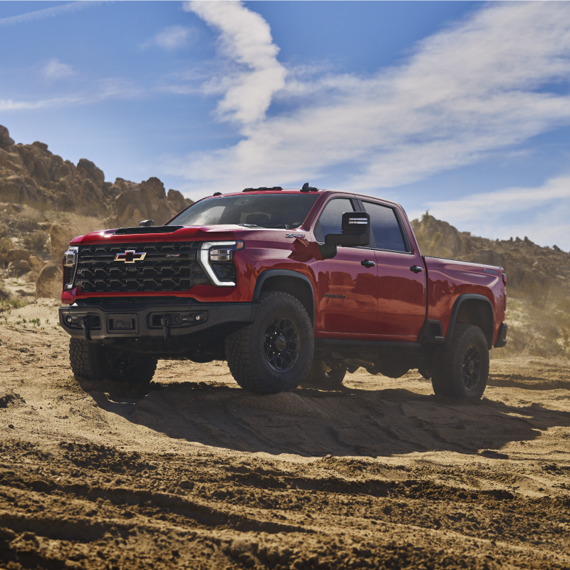 La nouvelle camionnette tout-terrain Chevrolet Silverado HD 2027 traverse un sentier désertique accidenté, vue d’un angle avant aux trois quarts.