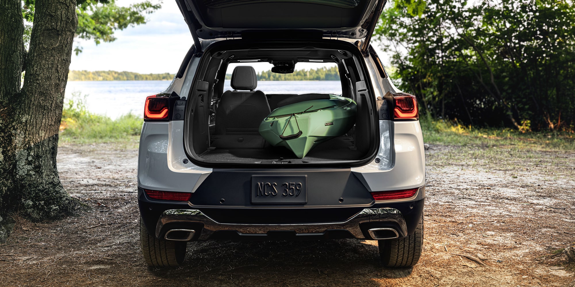 Rear view of a white 2027 Chevrolet Trailblazer with the liftgate open, showcasing the spacious cargo area with luggage inside.