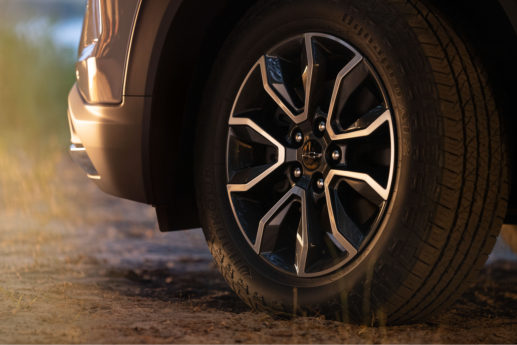 Plan rapproché d’une roue en alliage et d’un pneu Chevrolet Trailblazer 2027 sur une surface en terre.
