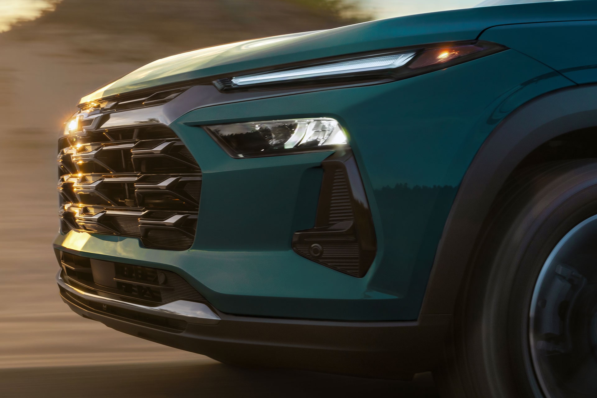2027 Chevrolet Trax small SUV front-end detail featuring a black grille, Chevrolet bowtie emblem and LED lighting.