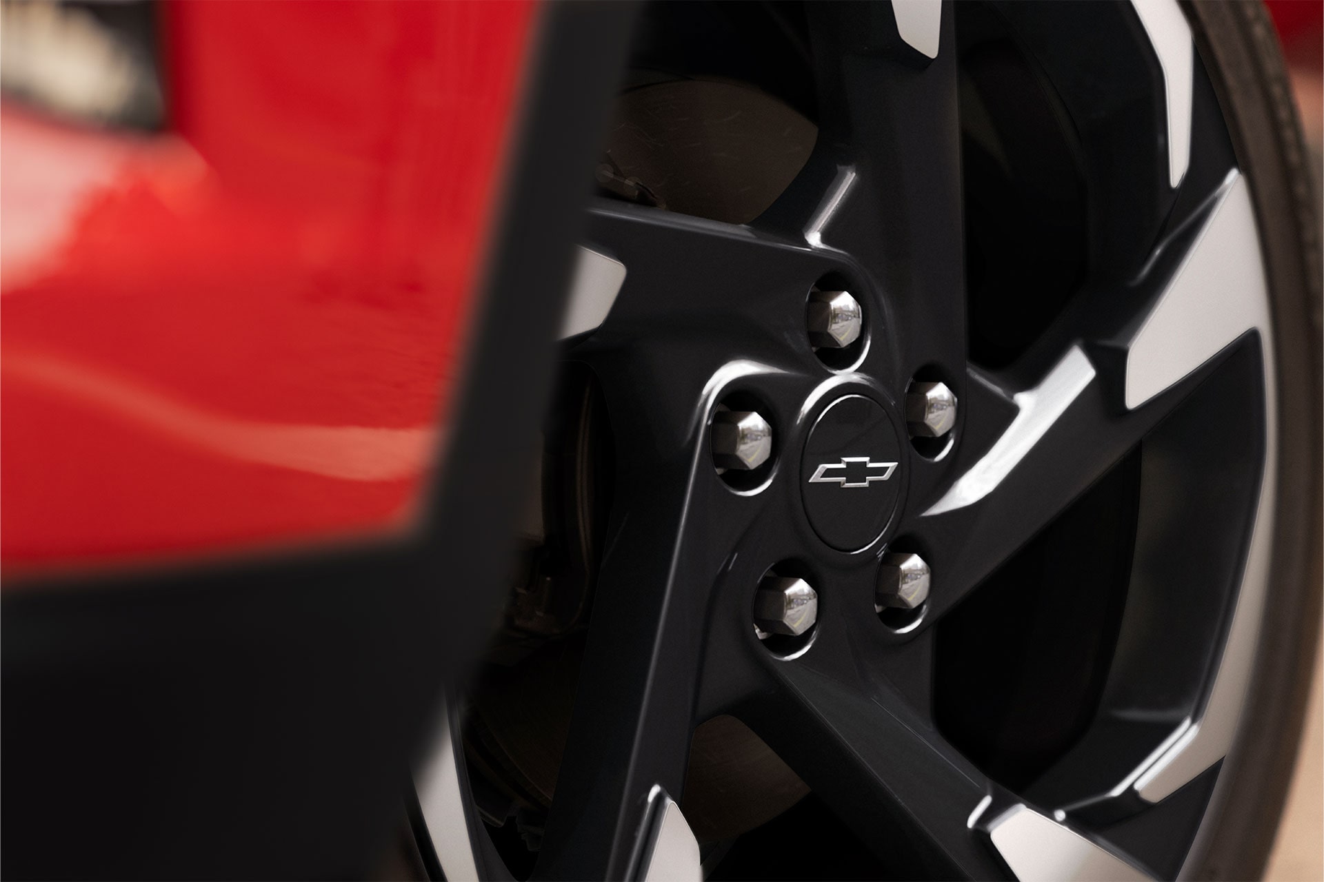 Close-up of a black and machined alloy wheel on the 2027 Chevrolet Trax small SUV, highlighting the Chevrolet bowtie center cap and wheel design details.