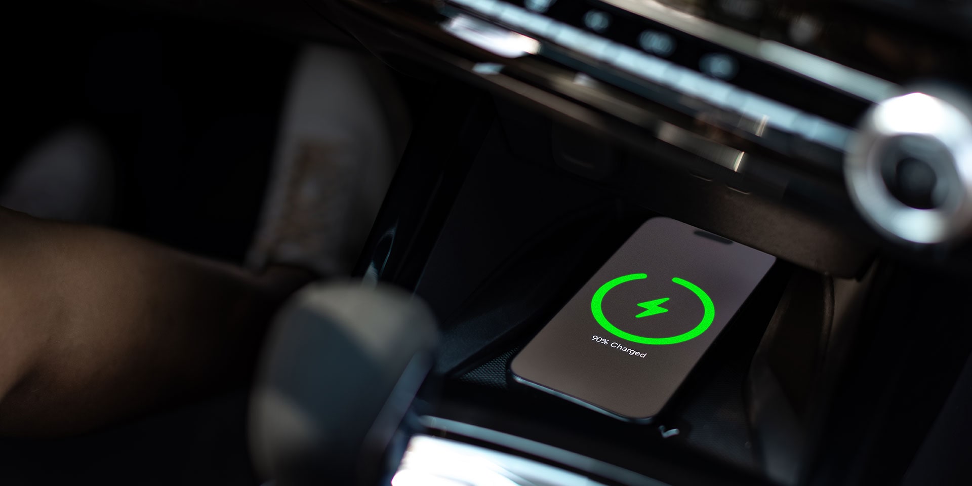 Wireless charging pad in the center console of the 2027 Chevrolet Trax small SUV, showing a smartphone charging alongside the vehicle’s interior controls and dashboard.