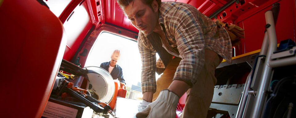 Workers carrying equipment to the 2022 Chevrolet Express Cargo Van.