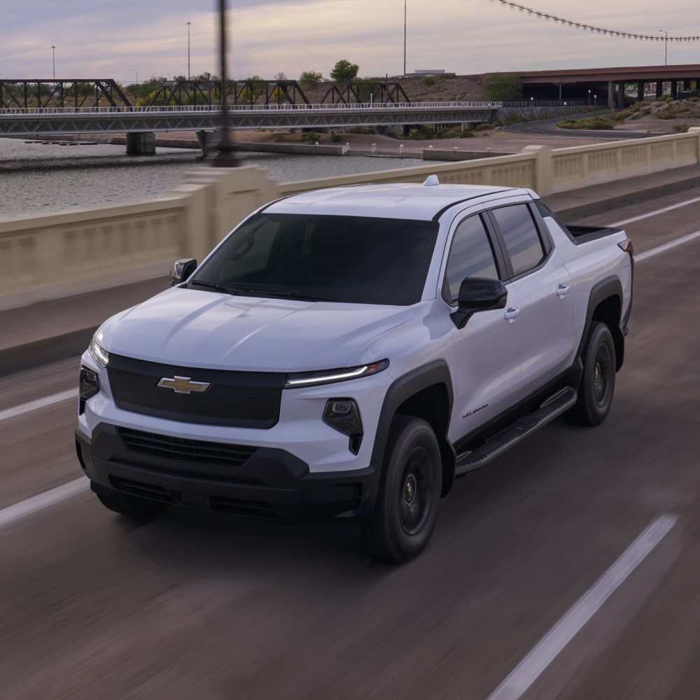 2026 Chevrolet Silverado EV Work Truck Driving Over a Highway Bridge.