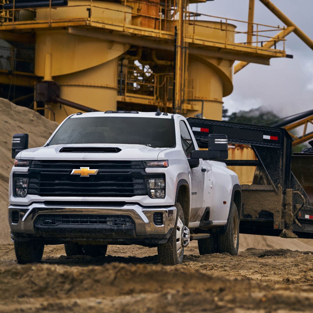 The 2026 Chevrolet Silverado HD Work Truck Towing a Bulldozer on a Construction Site.