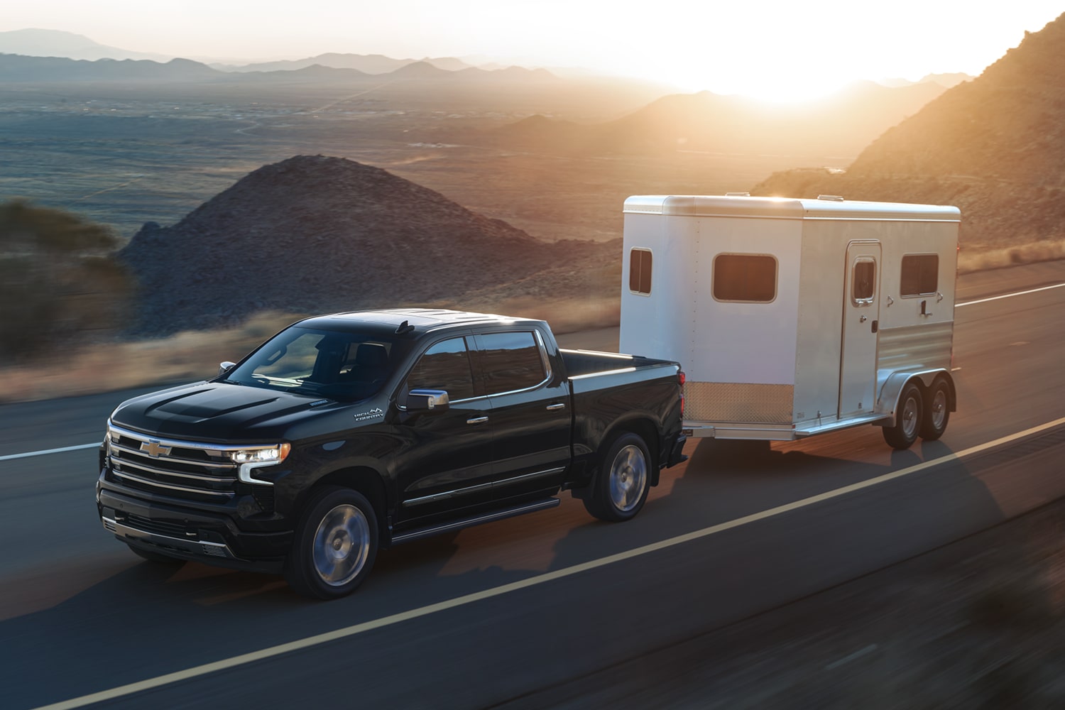 Le camion de travail Chevrolet Silverado LD commercial 2026 qui tire une remorque sur une autoroute.