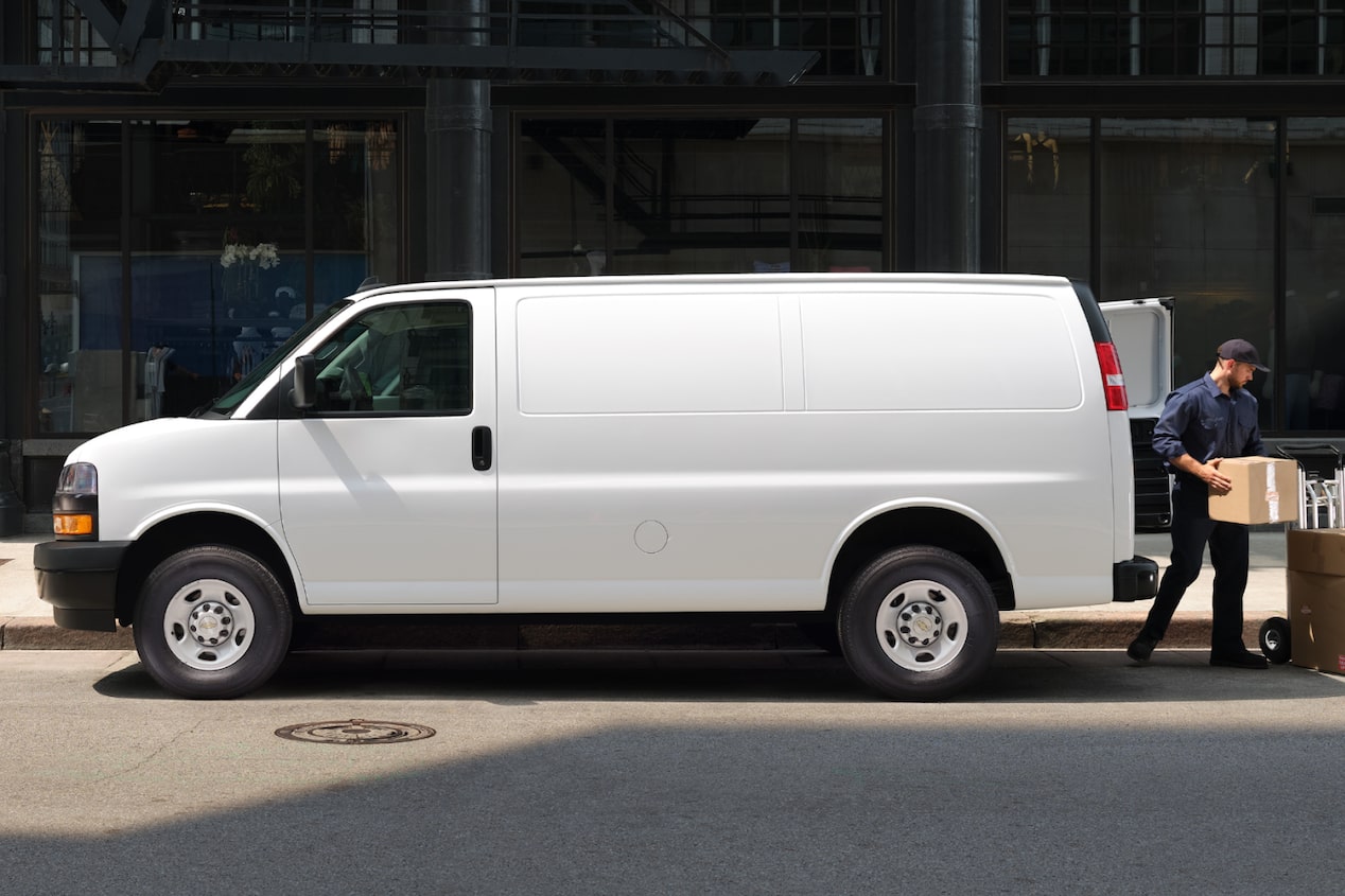 Side view of a Chevrolet Express Cargo Van parked outside a building.