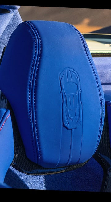 Vue rapprochée des appuie-têtes bleus de la Chevrolet Corvette Grand Sport 2027 avec un logo Corvette imprimé dans le matériau.