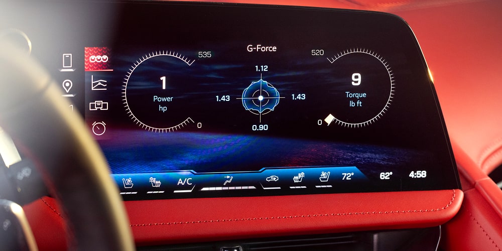 Un gros plan d’un tableau de bord numérique à l’intérieur de la Chevrolet Corvette ZR1 2027 affichant les informations de conduite sur un grand écran avec des graphismes d’interface bleus et un entourage rouge du tableau de bord.