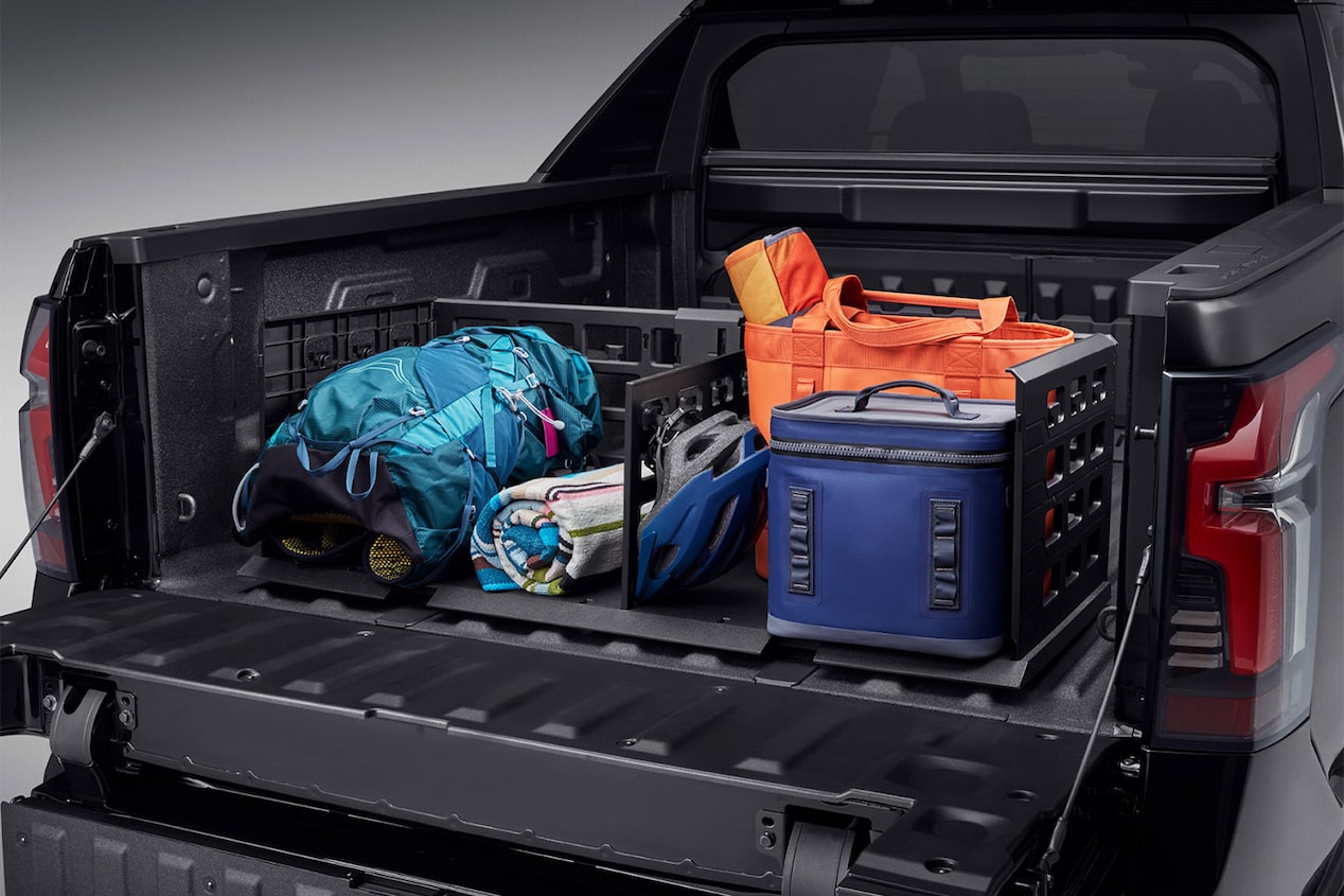 Des sacs et du matériel sont rangés dans la caisse d’un Chevrolet Silverado EV.